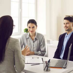 couple receiving advice from realtor at a desk