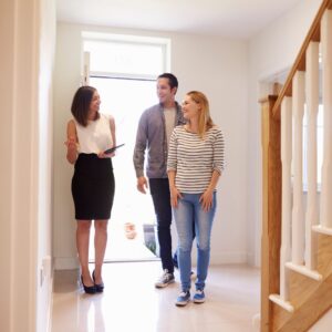 Couple entering home with a realtor for a showing