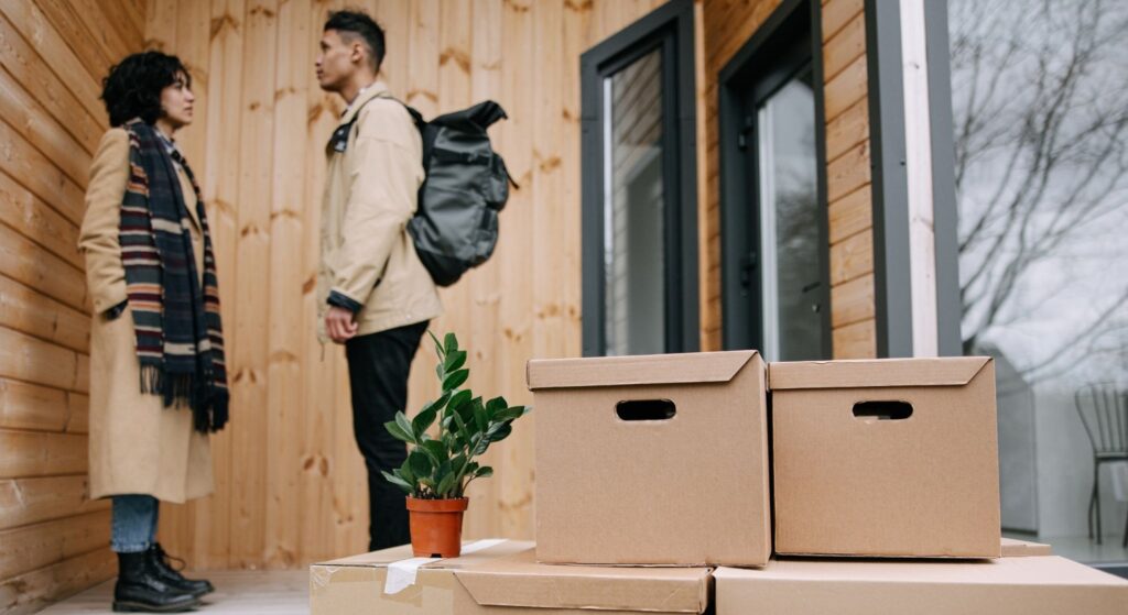 couple standing on stoop with moving boxes